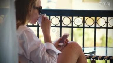 在炎热的夏天，一个女人在阳台上一边打短信一边喝茶